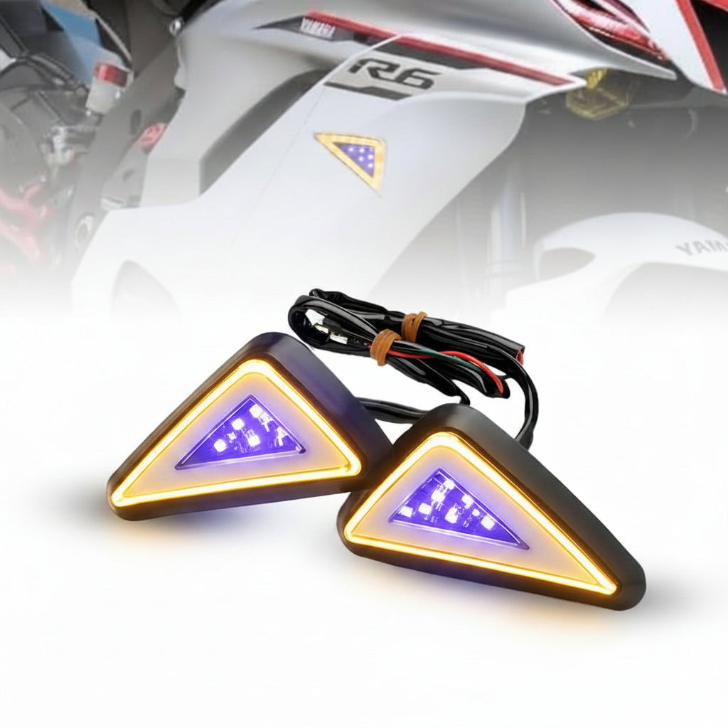 Pair of motorcycle turn signals with wiring on a blurred background