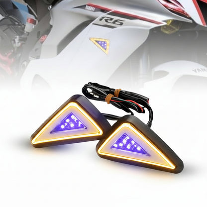 Pair of motorcycle turn signals with wiring on a blurred background